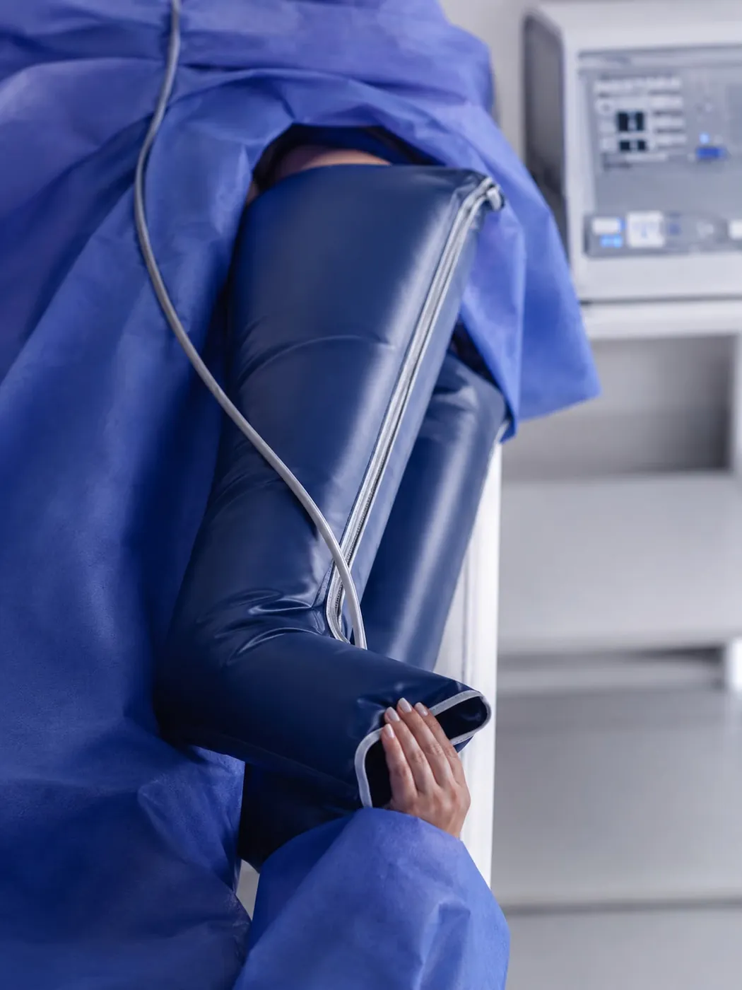 Paciente con bota de compresión neumática conectada a un equipo de presoterapia